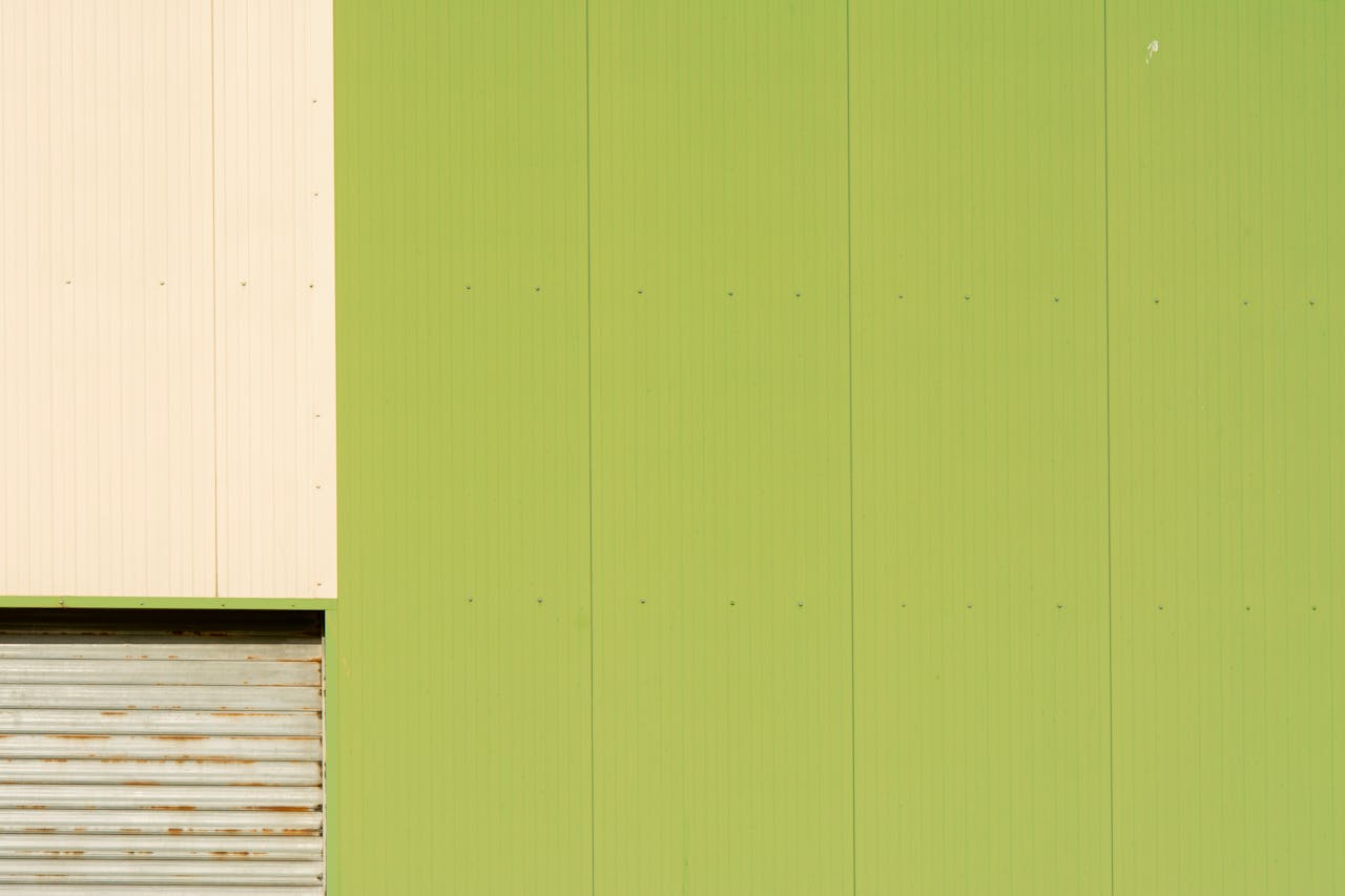 services-04 Industrial green facade with abstract forms and garage door detail.